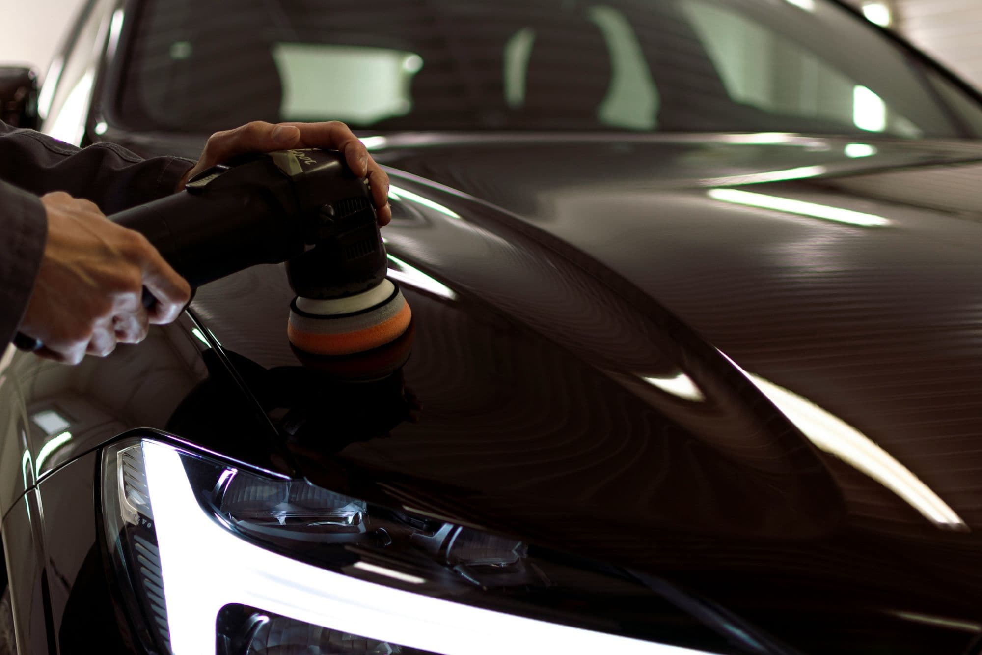 A car's bonnet being machine polished before collection